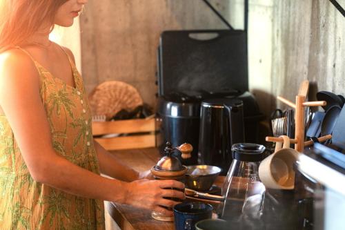 a woman standing in a kitchen with a coffee pot at "NICE!" Ocean view of Ishigaki island, Okinawa/ Four-bedroom Villa in Ishigaki Island