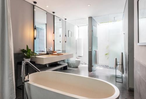 a bathroom with a large tub and a sink at Amarin Seminyak in Seminyak
