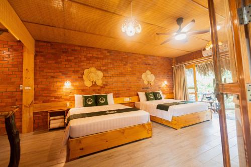 a bedroom with two beds and a ceiling fan at Mekong Rustic Riverside in Ấp An Nhơn (3)