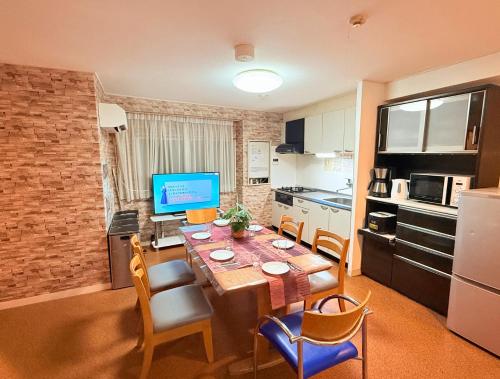 a kitchen with a table with chairs and a television at M2-3Haneda Lex House 9BDR Max22 people 2WC 2Bath 1min from Sta FreeParking 'Private use in Tokyo