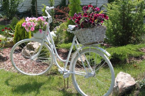 Una bicicleta blanca con una cesta llena de flores en Alexandria Hotel, en Pryluky