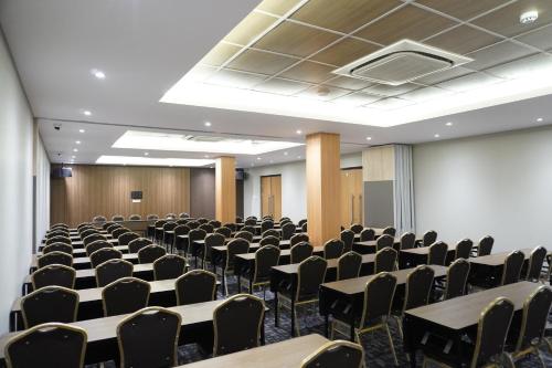 a room with rows of tables and chairs at Front One Hotel Papua Lestari in Timika