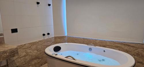 a bath tub sitting in a bathroom with at Pousada Alpes Azul in Campos do Jordão