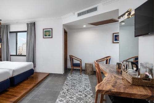 a hotel room with a bed and a desk at Pacific Hotel in Phnom Penh
