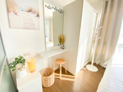 カトゥーにあるLuxury Condo Near Patong Beach & Shopping Mallの鏡とスツールのある小さな白い部屋