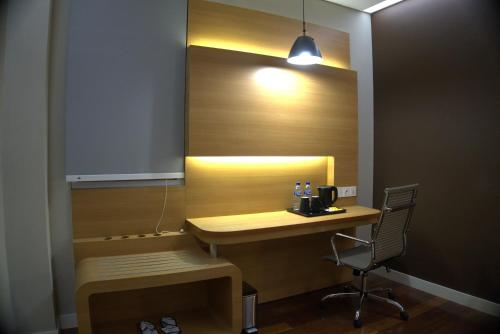 a room with a desk with a chair and a light at Front One Hotel Papua Lestari in Timika
