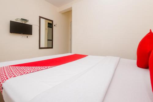 a bedroom with a white bed with a red blanket at Hotel O Diplomat in Sopāra