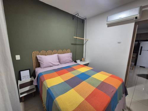 a bedroom with a colorful bed in a room at Ed Gift Home Setor Oeste in Goiânia