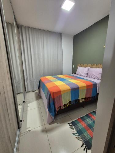 a bedroom with a bed with a colorful blanket at Ed Gift Home Setor Oeste in Goiânia
