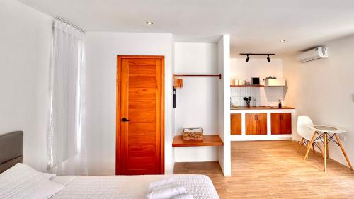 a bedroom with a wooden door and a kitchen at Apartamento en Galápagos #11 in Puerto Baquerizo Moreno