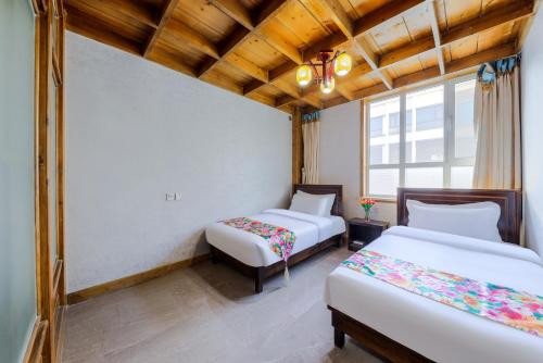 a room with two beds and a window at Fucheng Siheyuan in Zhangye