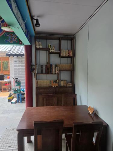 a dining room with a wooden table and chairs at Fucheng Siheyuan in Zhangye