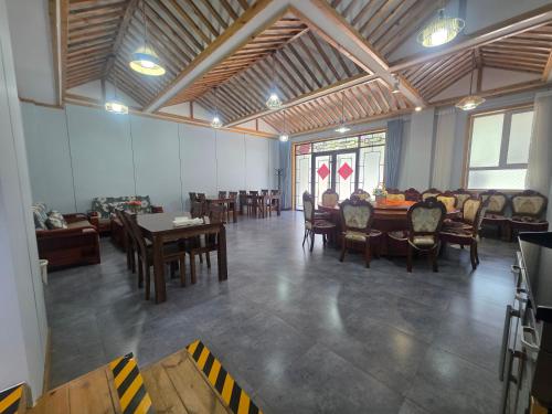 a large room with a table and chairs in it at Fucheng Siheyuan in Zhangye