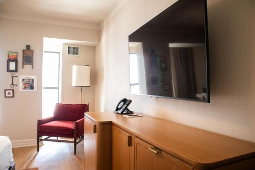 a bedroom with a red chair and a mirror at Hutton Hotel in Nashville