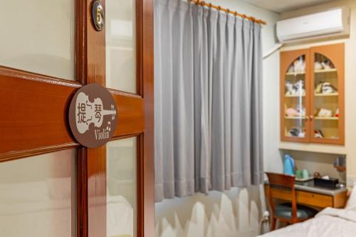 a room with a bed and a window with a curtain at Hill Side B&B in Yuchi