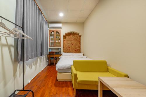 a bedroom with a bed and a yellow chair at Hill Side B&B in Yuchi