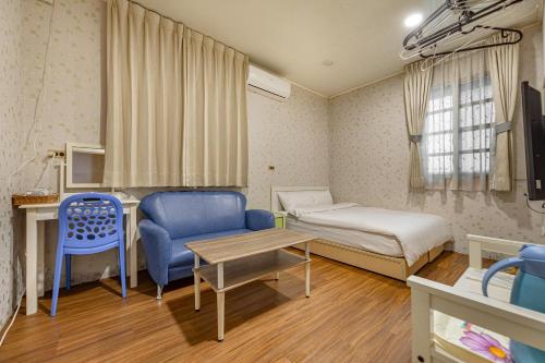a small room with a bed and a table at Hill Side B&B in Yuchi