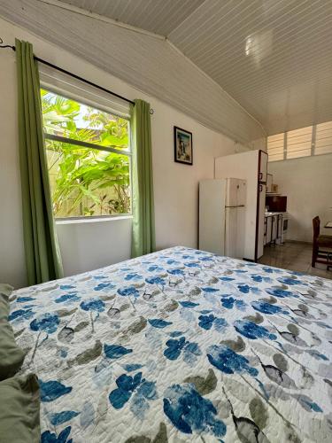 a bedroom with a bed and a window and a refrigerator at Villas Cozy Sloth in Puerto Viejo
