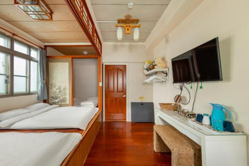 a bedroom with a bed and a flat screen tv at Hill Side B&B in Yuchi