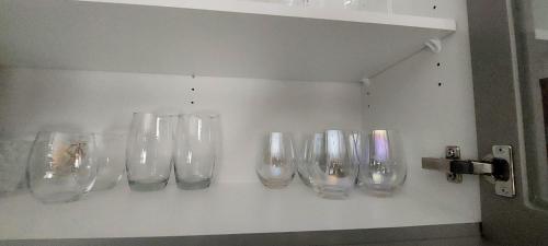 a row of empty wine glasses on a wall at Little Heaven 2BR southwest Calgary in Calgary