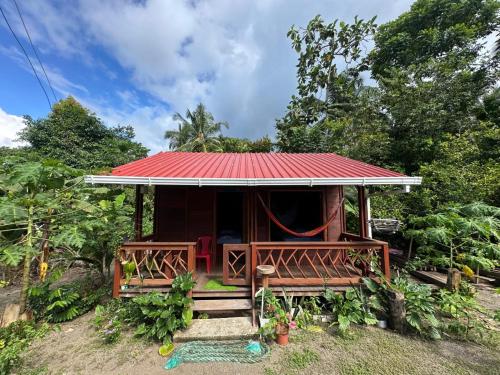 una pequeña casa con techo rojo en la bamba, cabaña barracuda, en Nuquí
