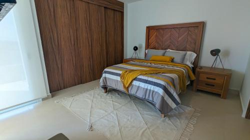 a bedroom with a bed with a wooden headboard at Your Perfect Getaway in Vallarta, Pool & Balcony in Nuevo Vallarta