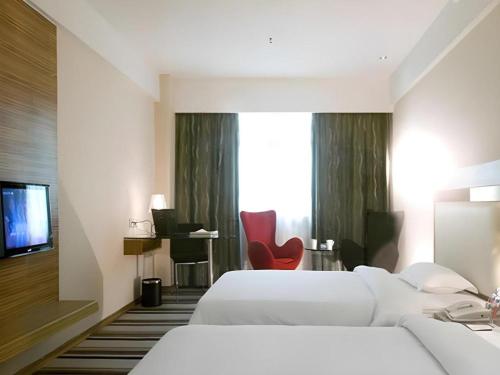 Кровать или кровати в номере Orient Sunseed Hotel Airport Branch