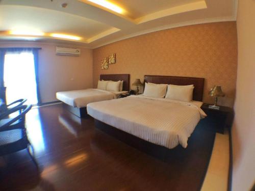 a hotel room with two beds and a window at Grand Hoyah Hotel in Olongapo