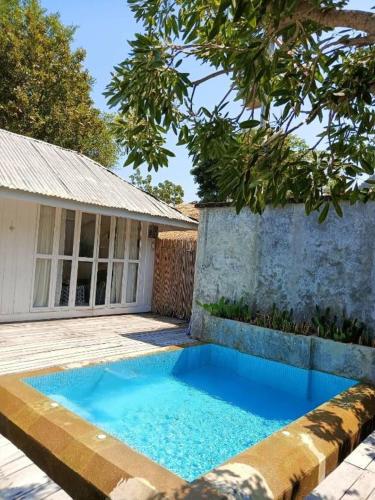 a blue swimming pool in front of a house at Brassiere Beach Hotel in Baanphakrimlay 