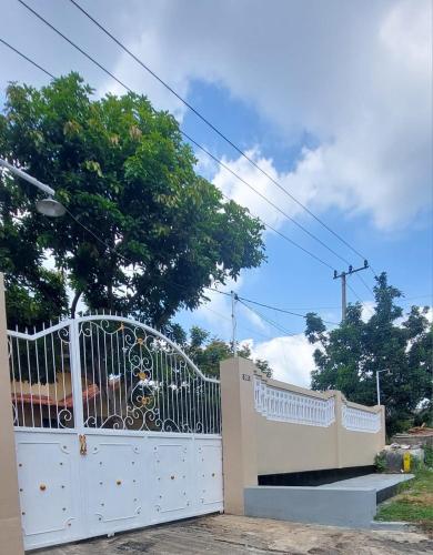 a white gate in front of a house at Bromo Stay Hostel in Probolinggo