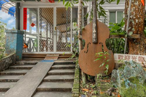 a guitar hanging on the side of a building at Hill Side B&B in Yuchi