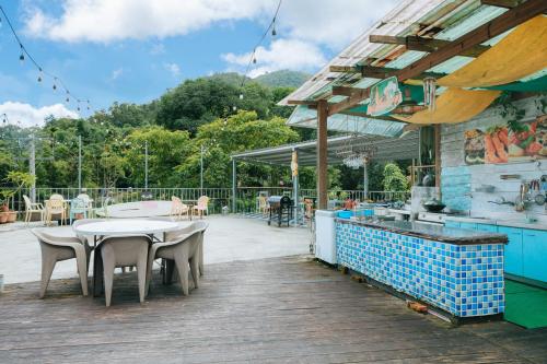 a patio with a table and chairs on a deck at Hill Side B&B in Yuchi