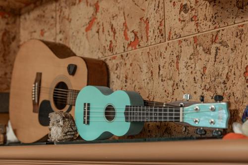 a guitar on a wall with a bird next to it at Hill Side B&B in Yuchi