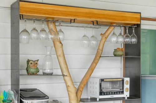 a kitchen with a shelf with wine glasses and a microwave at Hill Side B&B in Yuchi