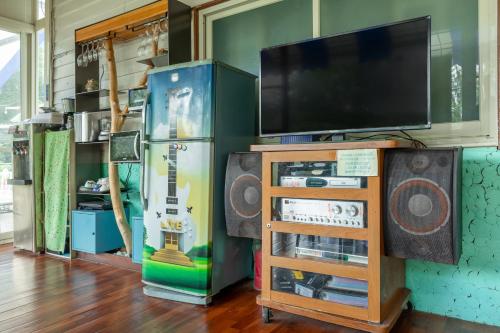 a room with a flat screen tv and a tv stand at Hill Side B&B in Yuchi