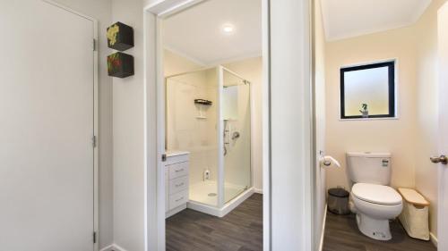 un bagno bianco con wc e doccia di Tepuia Cottage - Havelock Holiday Home a Picton