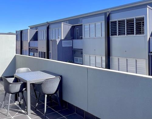 a table and chairs on the balcony of a building at Crown on Darby Newcastle in Newcastle