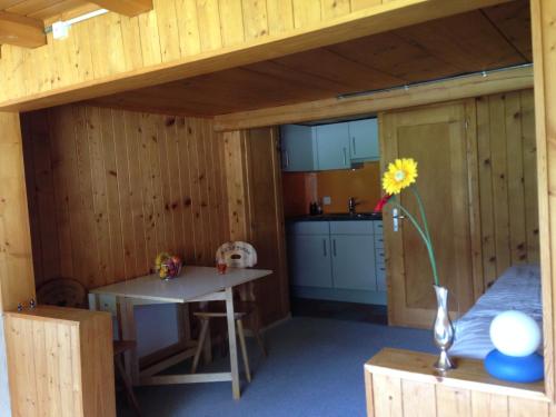 eine Küche in einer Holzhütte mit einem Tisch in der Unterkunft Studio Sternen in Hasliberg