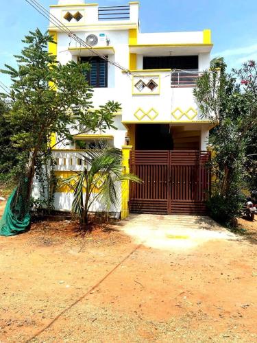 a house with a wooden gate in front of it at Maison Douce home stay 3BHK Serenity in Puducherry