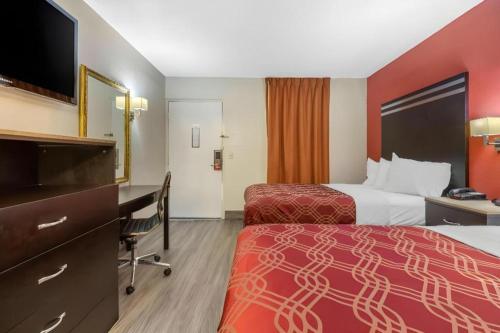a hotel room with two beds and a desk at Econo Lodge Columbia Fort Jackson in Burnside East