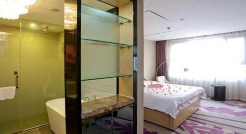 baño con cama y bañera junto a un dormitorio en Lavande Hotel Jinan Quancheng Road Baotu Spring Branch, en Jinan