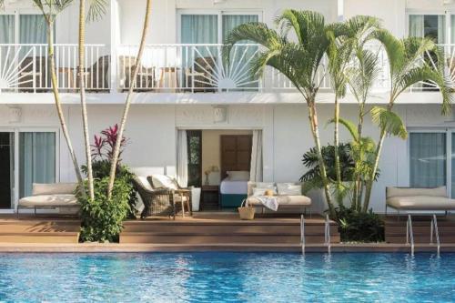 a hotel with a swimming pool and palm trees at EXCELLENCE PUNTA CANA - ALL INCLUSIVE - ADULTS ONLY in Punta Cana