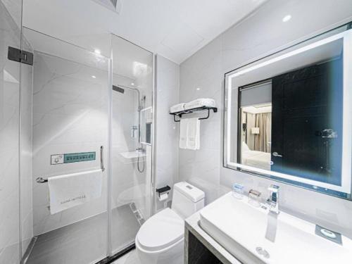 ein Badezimmer mit Toilette, Waschbecken und Spiegel in der Unterkunft Xana Hotelle Nanchang Honggutan in Nanchang