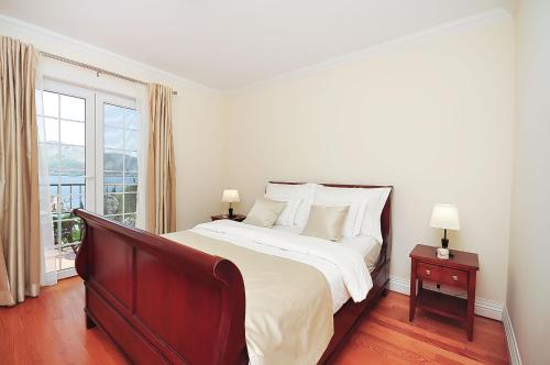 a white bedroom with a large bed and a window at Apartment Iva in Omiš