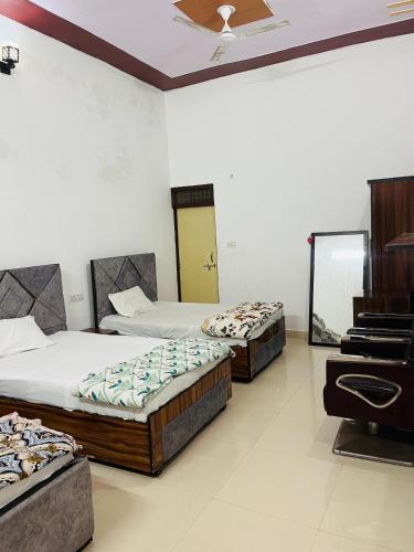 Habitación con 2 camas y piano. en New Monty palace inn, en Mathura