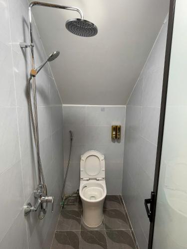 a small bathroom with a toilet and a shower at Subin Homestay Hue in Thôn Kim Long (1)