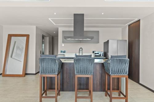 a kitchen with blue chairs and a kitchen counter at Unforgettable Holidays by the Ocean in Cruz de Huanacaxtle