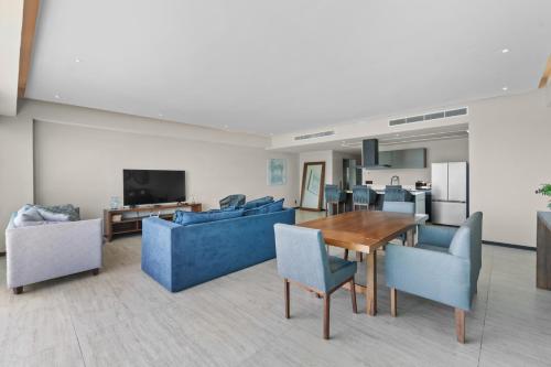 a living room with a table and blue chairs at Unforgettable Holidays by the Ocean in Cruz de Huanacaxtle