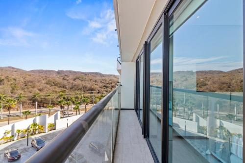 a balcony with glass walls and a view of a street at Beachfront and modern getaway in Bucerías