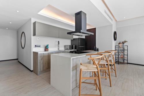 a kitchen with wooden chairs and a kitchen island with a counter top at Beachfront and modern getaway in Bucerías